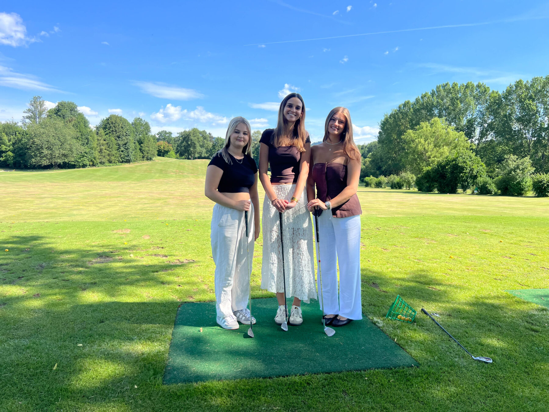 Drei Frauen mit Golfschlägern auf einem Golfplatz in Österreich.