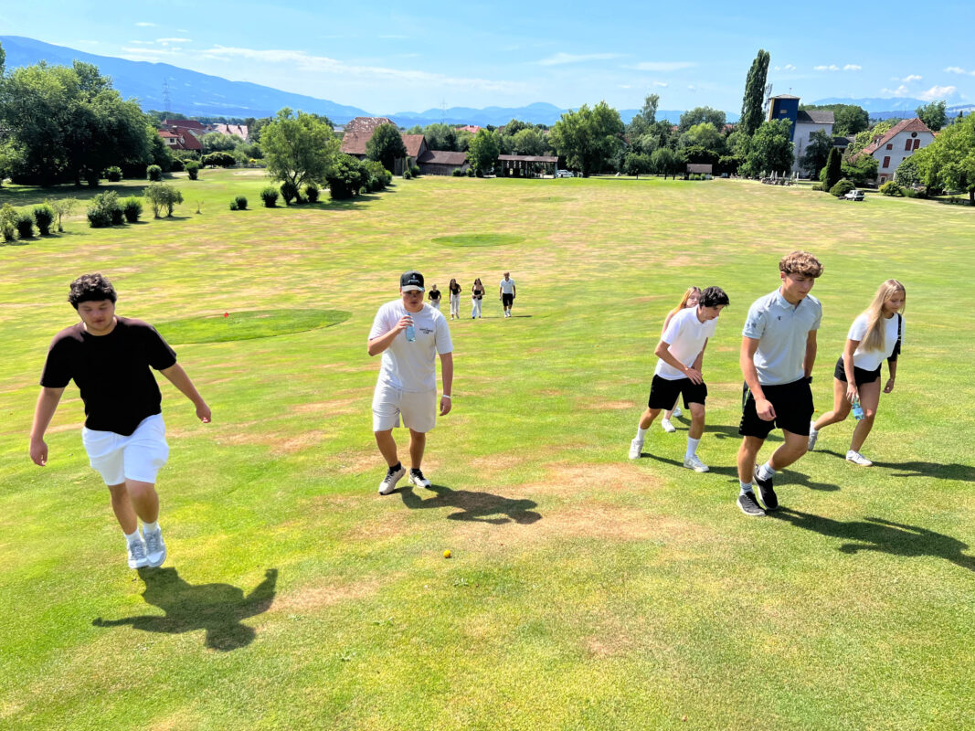 Jugendliche beim Golfen auf einem sonnigen Golfplatz in Österreich