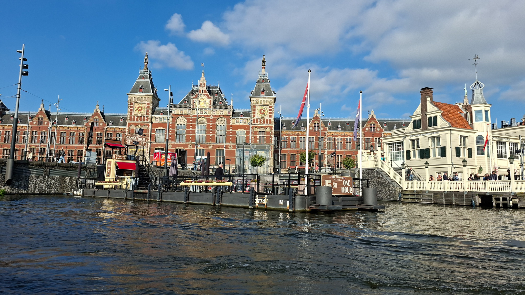 Amsterdam Centraal Station mit Anlegestelle und Kanalboot in Amsterdam